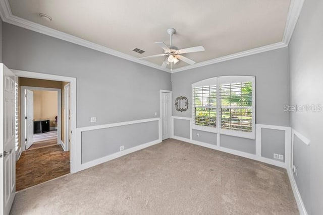 carpeted empty room featuring ornamental molding and ceiling fan