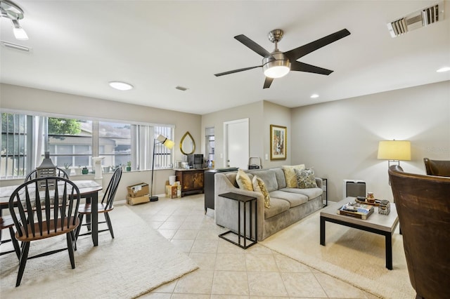 living area with light tile patterned floors, ceiling fan, and visible vents