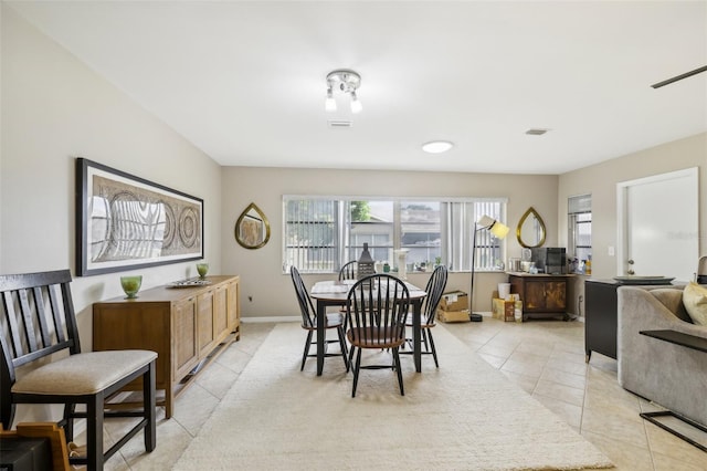 dining area with light tile patterned flooring, visible vents, and baseboards