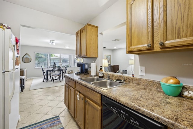 kitchen with light tile patterned floors, black dishwasher, freestanding refrigerator, light countertops, and a sink