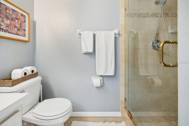 bathroom featuring baseboards, tiled shower, vanity, and toilet