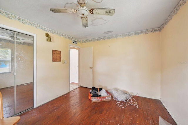 empty room with hardwood / wood-style floors and ceiling fan