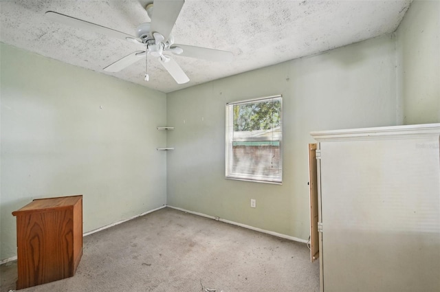 carpeted spare room featuring ceiling fan and a textured ceiling