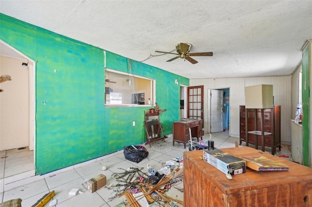 interior space with ceiling fan and a textured ceiling