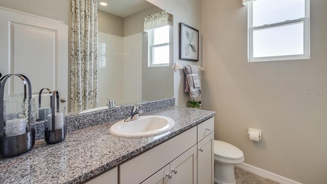 bathroom featuring tile patterned flooring, vanity, and toilet