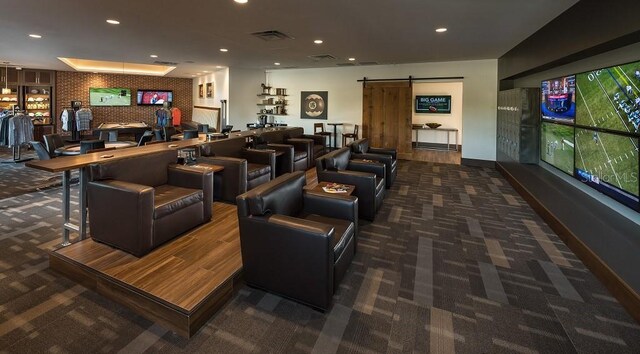 carpeted home theater featuring a barn door