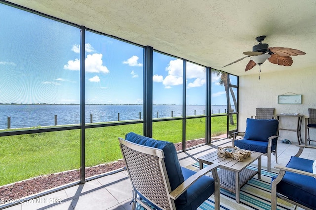 sunroom with a wealth of natural light, ceiling fan, and a water view