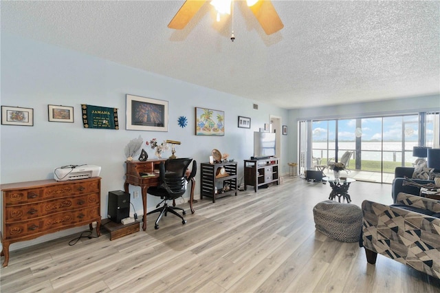 office space with ceiling fan, a textured ceiling, and light hardwood / wood-style flooring