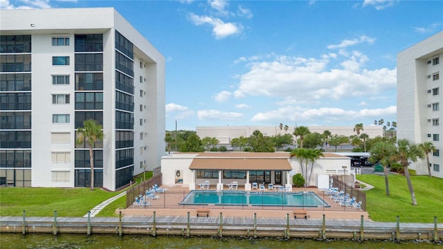 view of swimming pool featuring a yard, a patio, and a water view