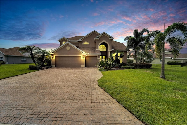 view of front of property featuring a garage and a yard