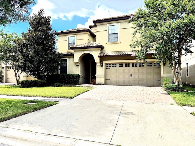 mediterranean / spanish home with a front lawn and a garage