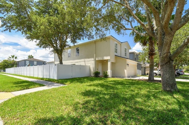 view of home's exterior featuring a yard, fence, and stucco siding