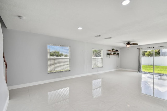 tiled spare room with ceiling fan and plenty of natural light