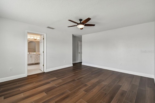 unfurnished bedroom featuring dark hardwood / wood-style flooring, ceiling fan, a textured ceiling, and ensuite bathroom