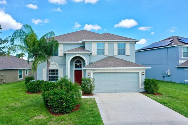 view of front of home with solar panels, a garage, and a front lawn