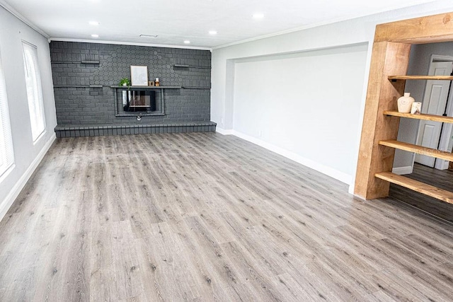 unfurnished living room with brick wall, crown molding, and wood-type flooring