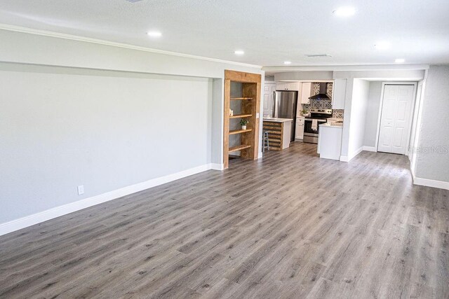 unfurnished living room featuring wood-type flooring and ornamental molding