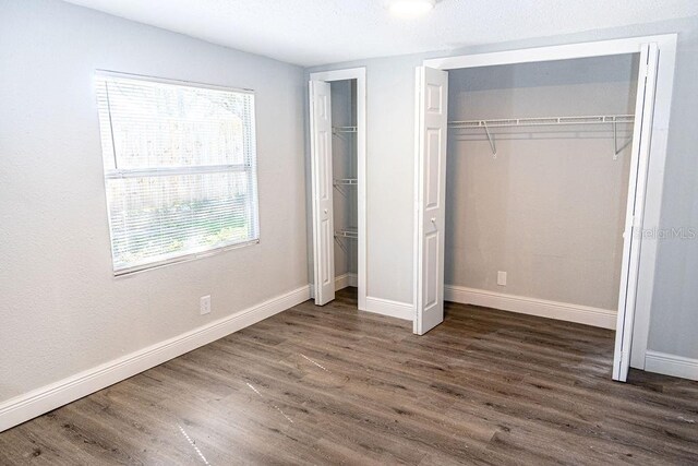 unfurnished bedroom with dark wood-type flooring