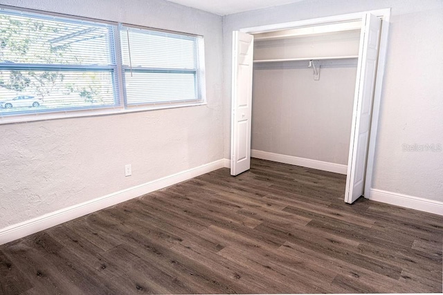 unfurnished bedroom with a closet and dark hardwood / wood-style floors