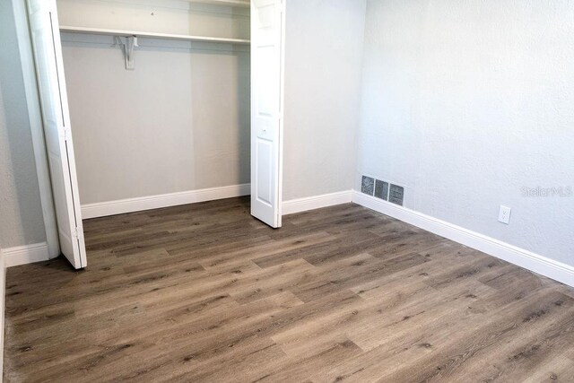 unfurnished bedroom with a closet and wood-type flooring