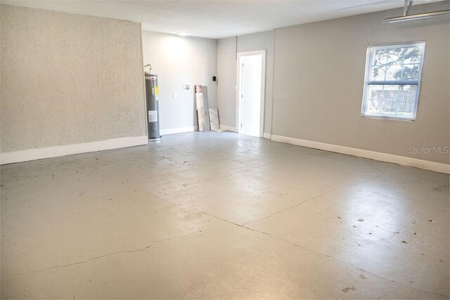 empty room with electric water heater and concrete flooring