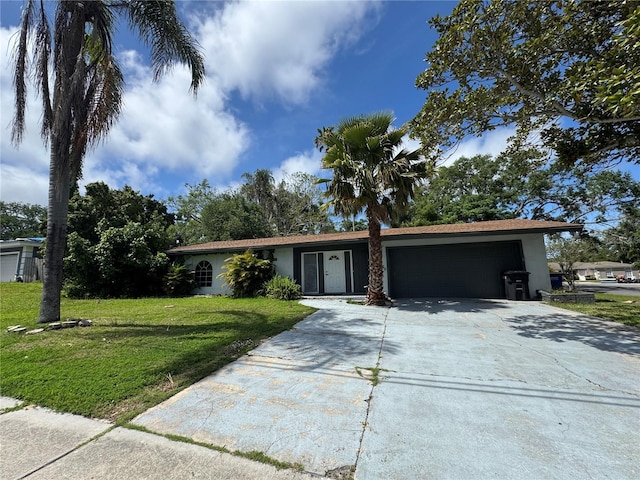 view of front of house featuring a front yard, a garage, stucco siding, and concrete driveway