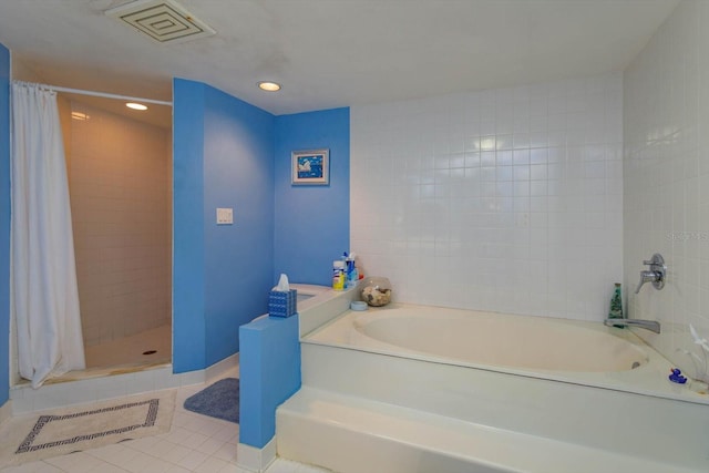 bathroom with tile patterned flooring and a bath