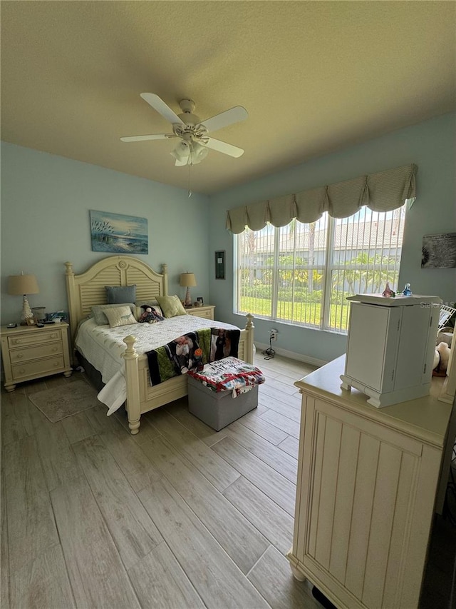 bedroom with light hardwood / wood-style flooring and ceiling fan