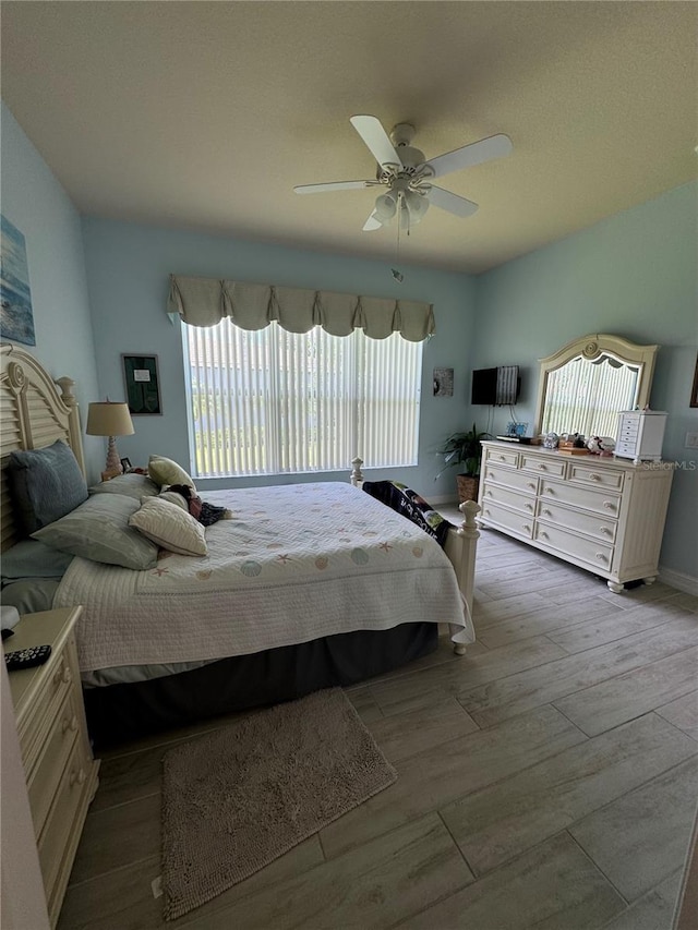 bedroom featuring multiple windows, ceiling fan, and hardwood / wood-style floors