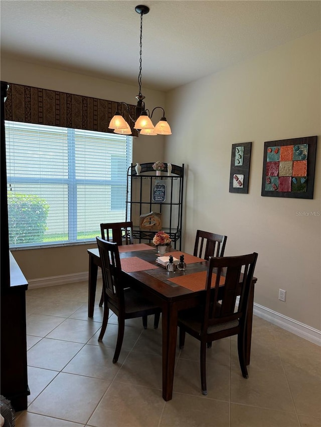 dining space with light tile patterned flooring and an inviting chandelier