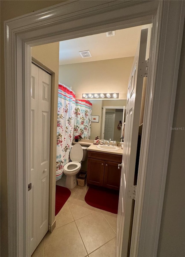 bathroom with vanity, tile patterned flooring, and toilet