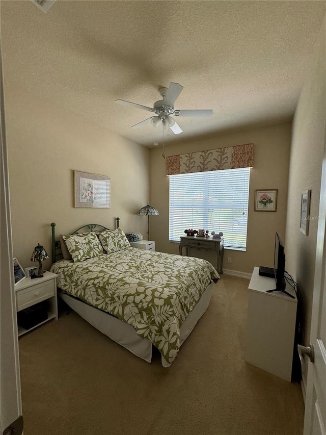 bedroom featuring carpet flooring, a textured ceiling, and ceiling fan