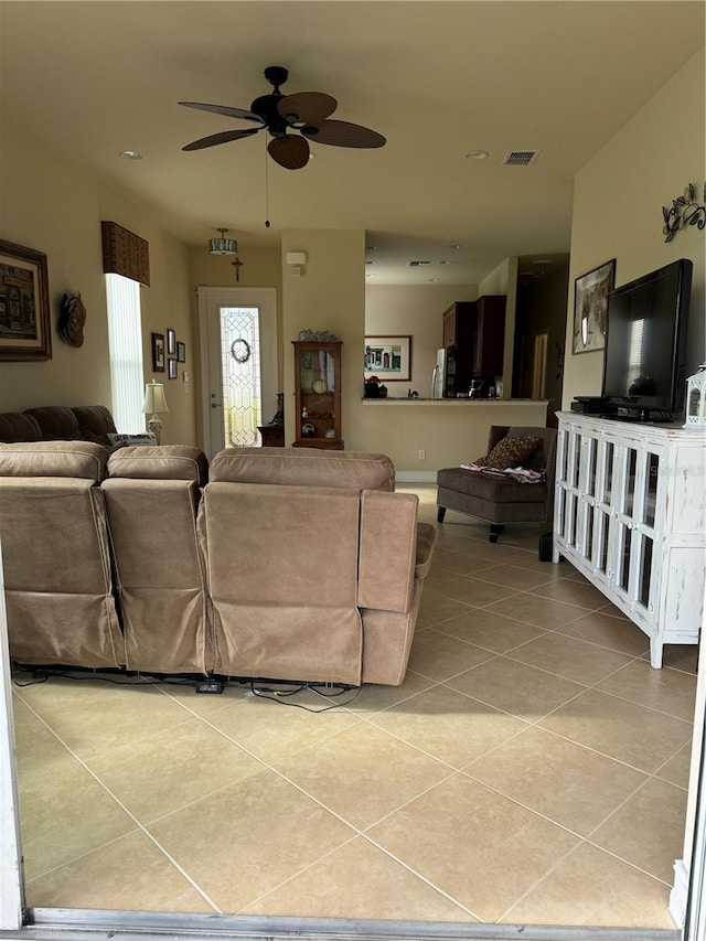 living room with a ceiling fan, visible vents, and light tile patterned floors