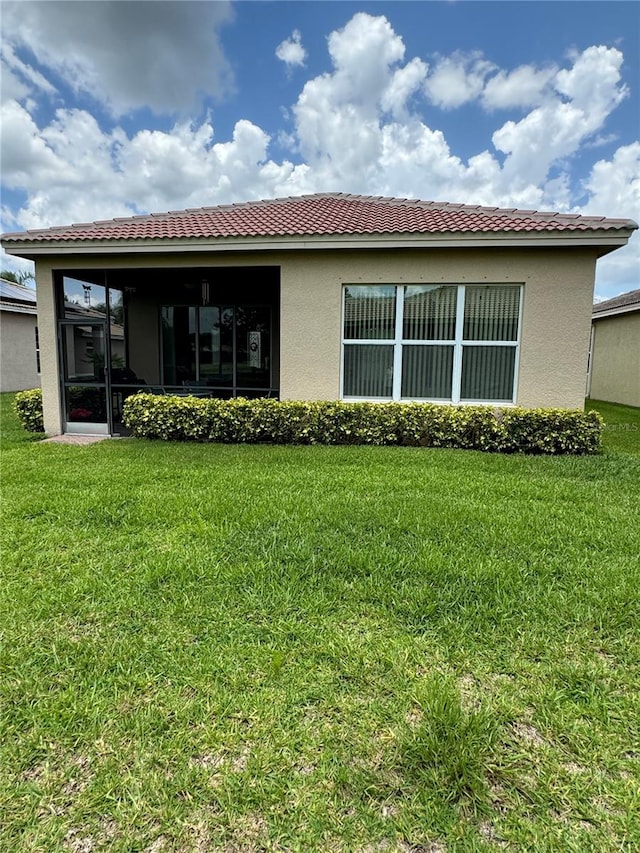 rear view of property with a lawn