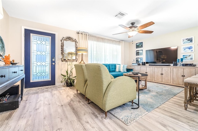 living room with light hardwood / wood-style floors and ceiling fan