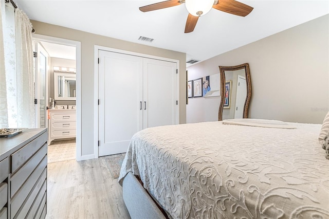 bedroom featuring ceiling fan, ensuite bathroom, light hardwood / wood-style flooring, and a closet