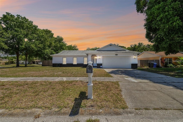 single story home featuring a garage and a yard