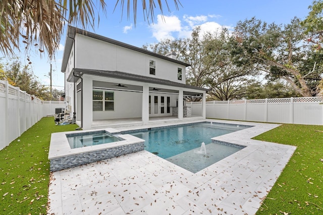 back of property featuring a swimming pool with hot tub, a yard, french doors, and ceiling fan