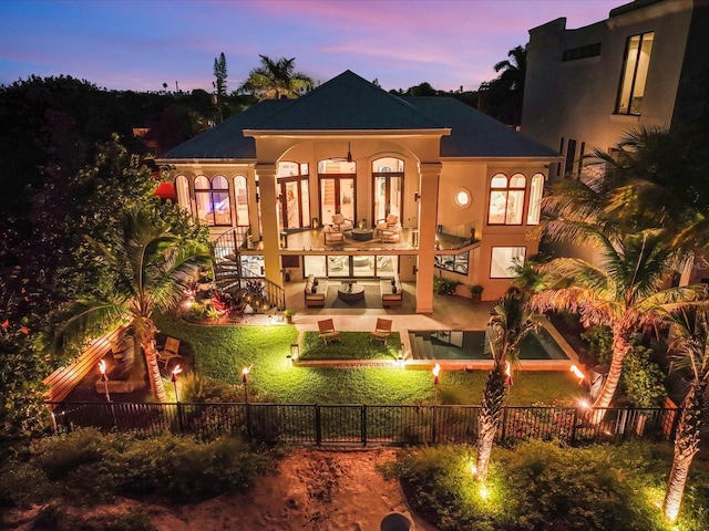 back house at dusk with a patio area