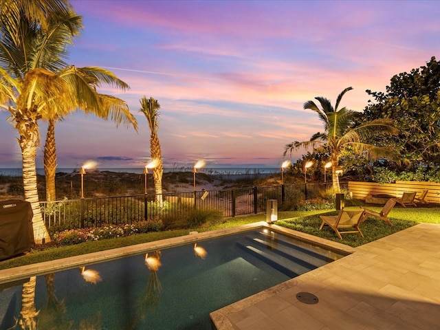 pool at dusk with a patio area