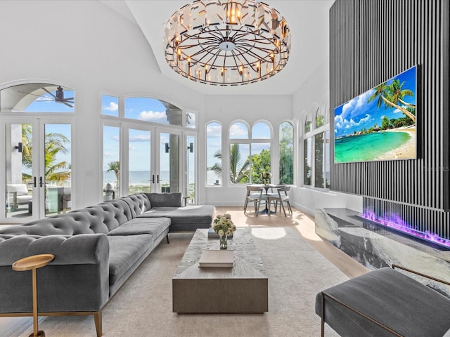 living room featuring a notable chandelier, french doors, and a high ceiling