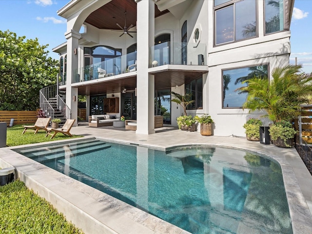 back of house featuring an outdoor living space, a balcony, a patio, and ceiling fan