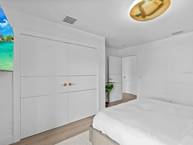 bedroom with a closet and light hardwood / wood-style flooring