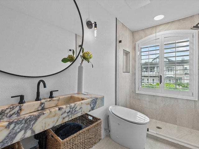 bathroom featuring a shower with door, sink, and toilet