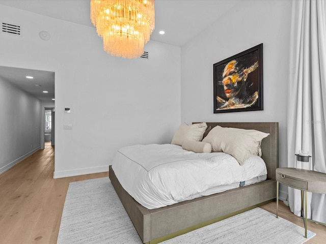 bedroom featuring a notable chandelier and light wood-type flooring