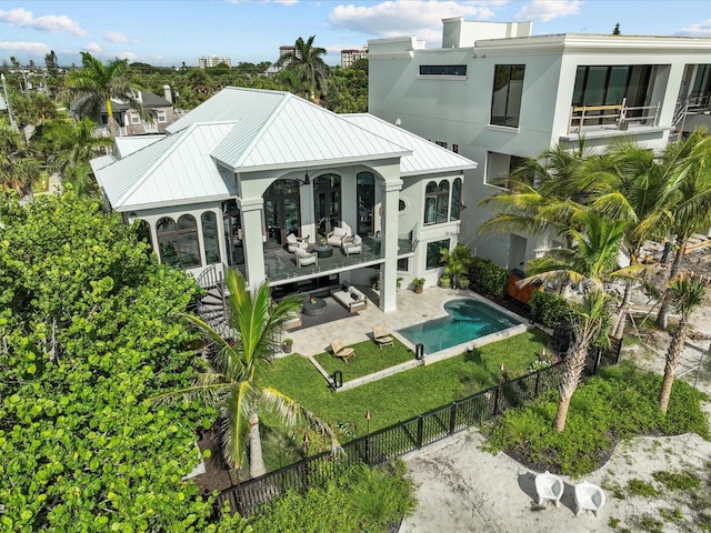 rear view of house with a balcony, an outdoor hangout area, a fenced in pool, and a patio