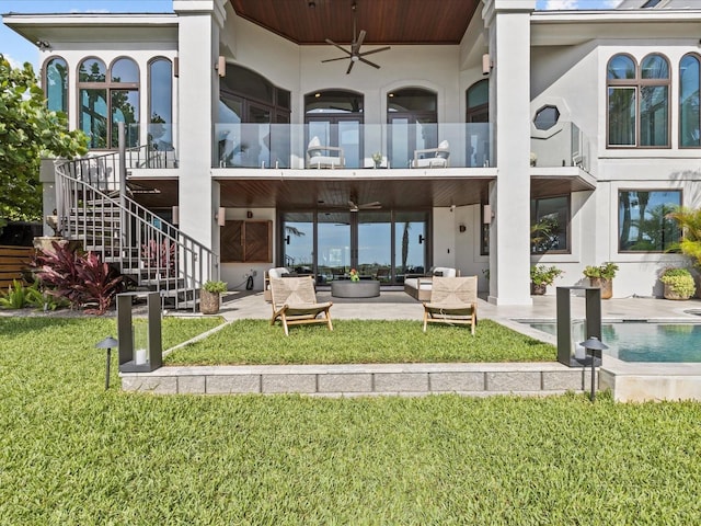 rear view of house with ceiling fan, a yard, and a patio area