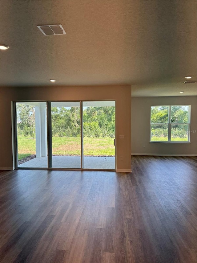 spare room featuring baseboards, dark wood-type flooring, recessed lighting, and a textured ceiling