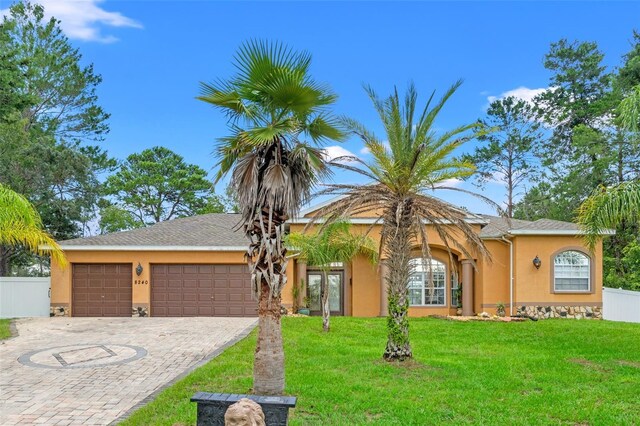 single story home featuring a garage and a front yard