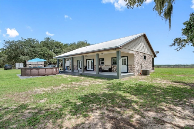 rear view of house featuring ceiling fan, a yard, central AC unit, and a patio area